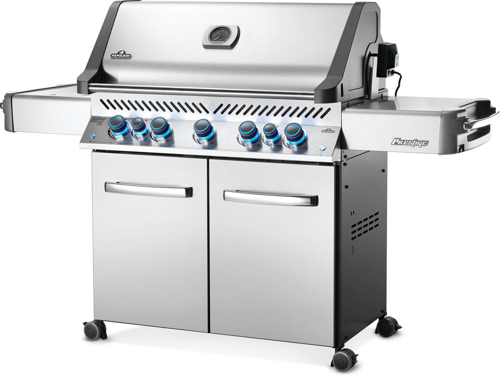 Front angle view of the beautiful stainless steel Prestige 665 RSIB gas grill, featuring sizzle zone side searing plates, interior lighting, rear infrared rotisserie burner, beautiful and safe control knobs, and more.
